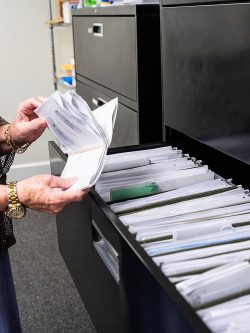 Hands of local Florida staff sifting through files and mail.