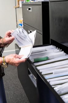 Hands of local Florida staff sifting through files and mail.