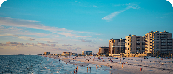 Beach view with high-rise building in the background and beachgoers near and in the water