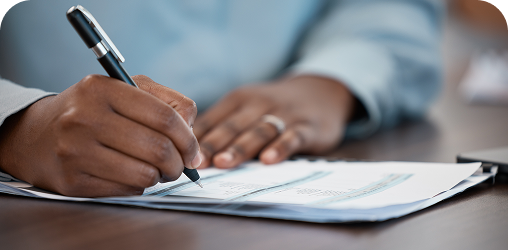 Close up on hands holding a pen, signing documents